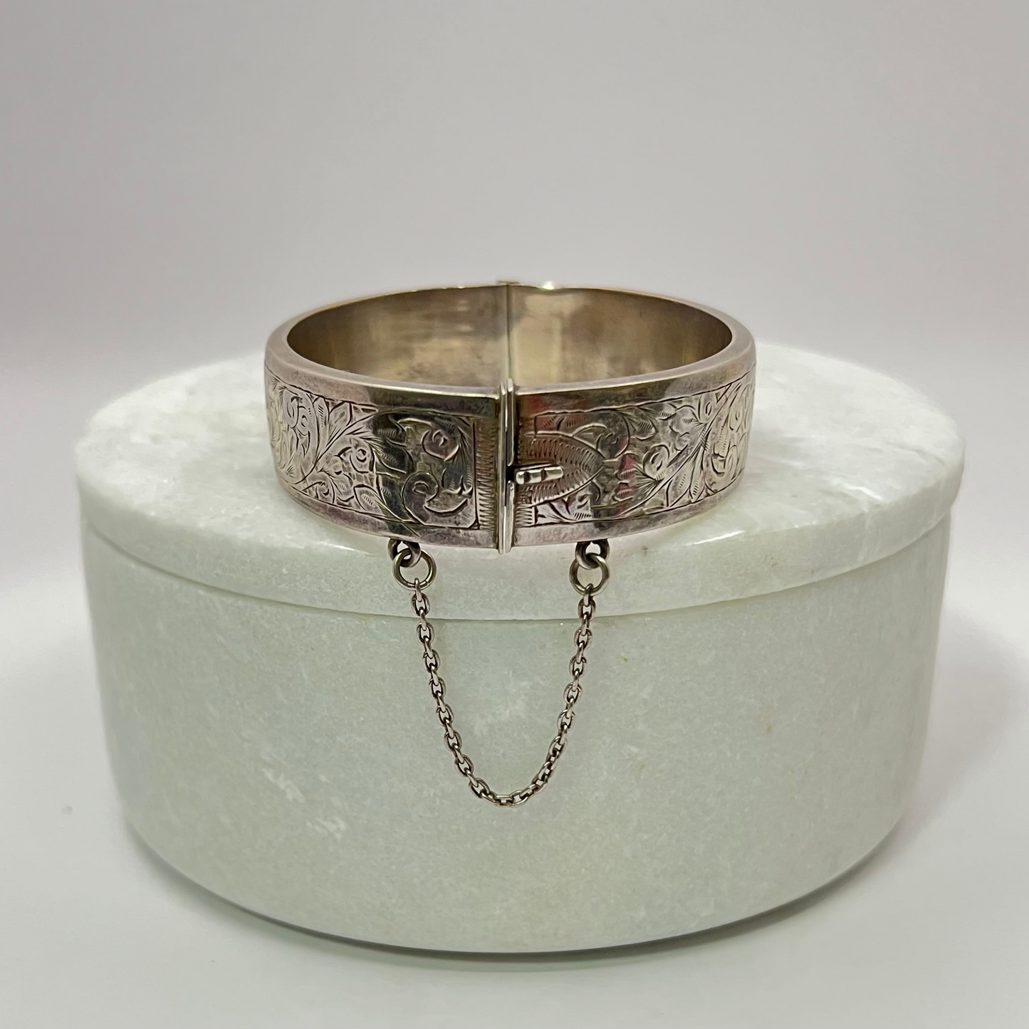 Vintage silver hand-etched hinged bangle with button clip and safety chain. Hudsons Estate Jewellery