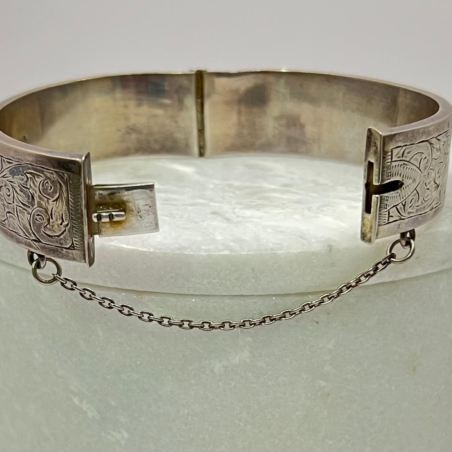 Vintage silver hand-etched hinged bangle with button clip and safety chain. Hudsons Estate Jewellery