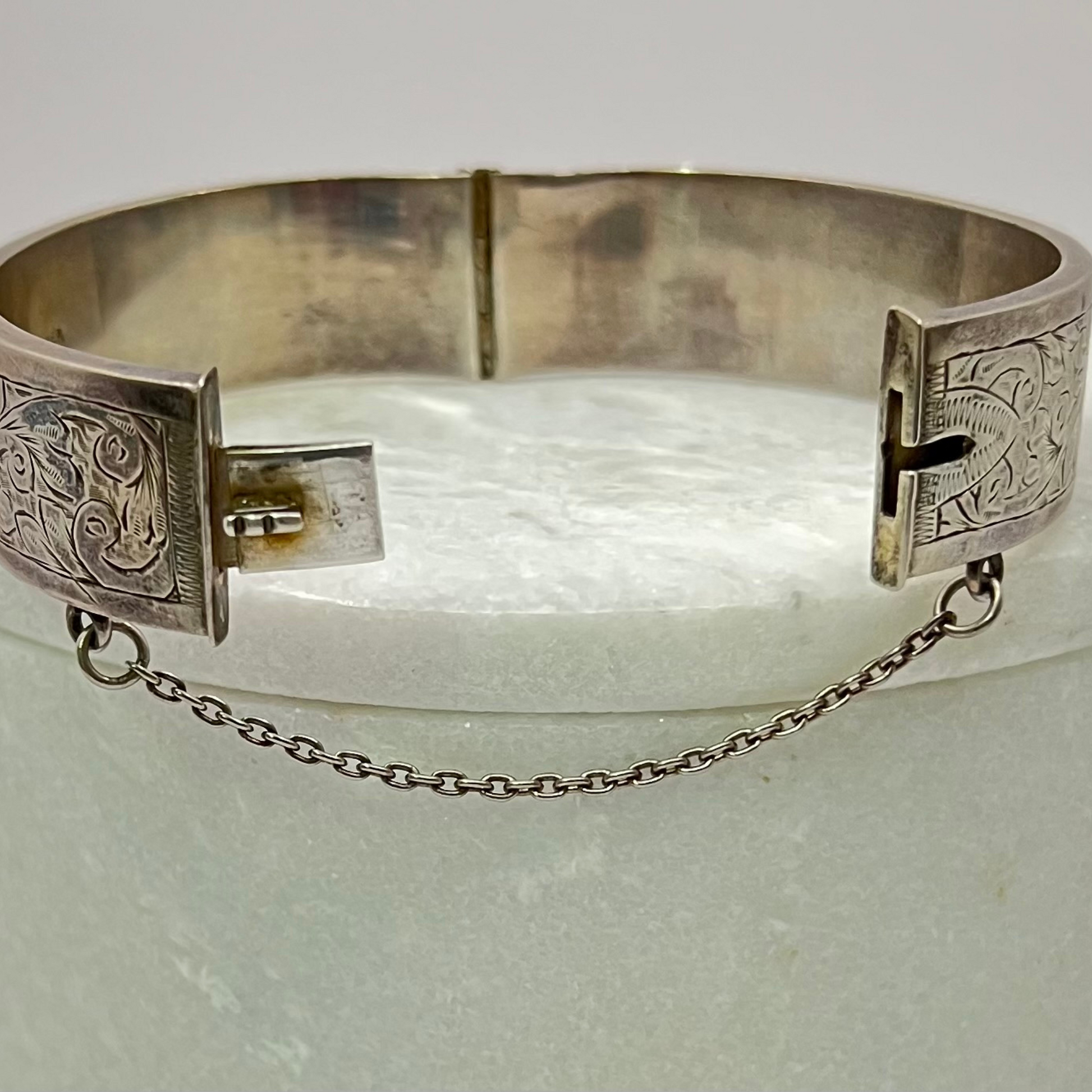 Vintage silver hand-etched hinged bangle with button clip and safety chain. Hudsons Estate Jewellery